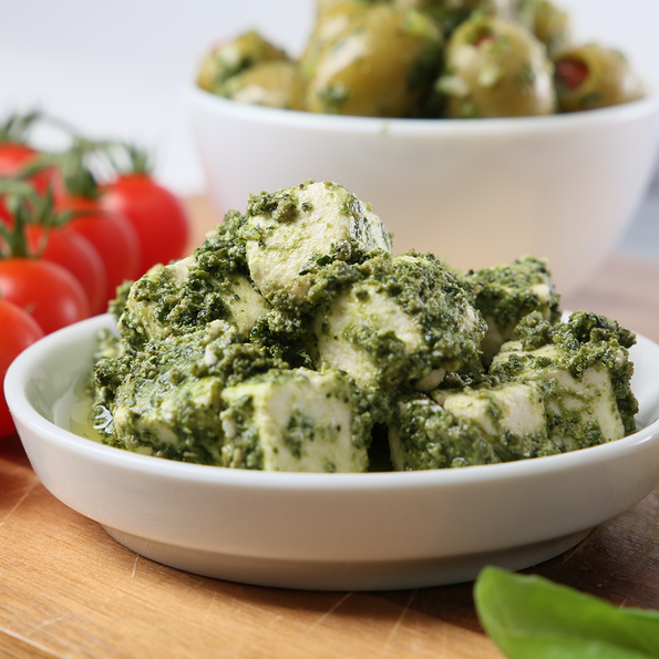 Weichkäsewürfel, eingelegt in Pesto